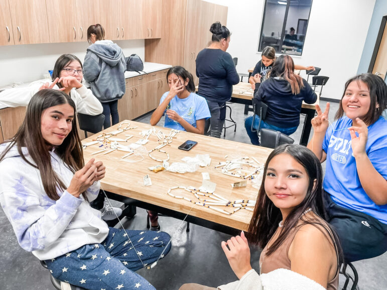 Children and adults are sewing at the Pine Ridge native american community center