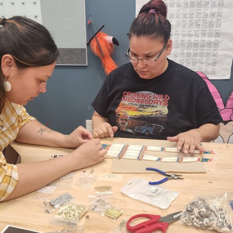 Two women working on a traditional Lakota breastplate.