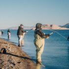 Community members fishing in cold weather by mountain lake