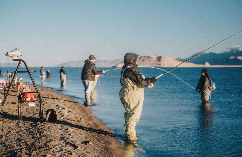 Community members fishing in cold weather by mountain lake