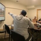 Presenter leading small group discussion with images on screen