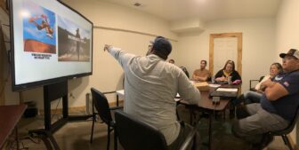 Presenter leading small group discussion with images on screen