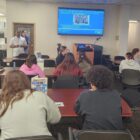 Instructor presenting to small group in classroom using large screen