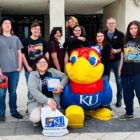 Group of students posing with KU mascot on campus tour