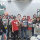 Native American students holding care packages in a classroom