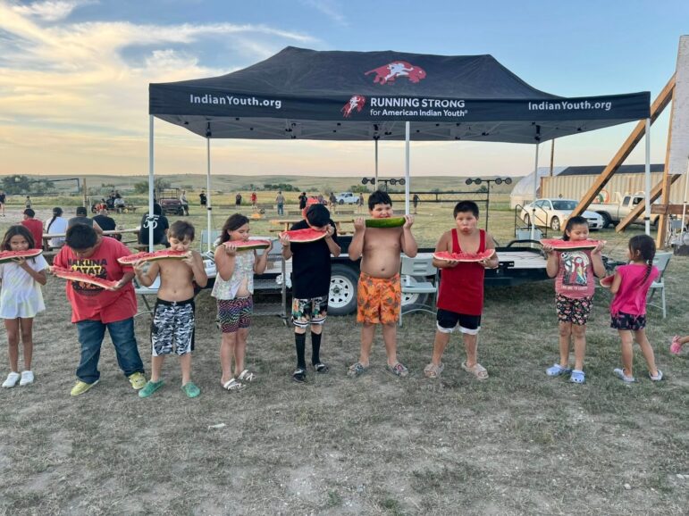 Running Strong youth program children eating watermelon together