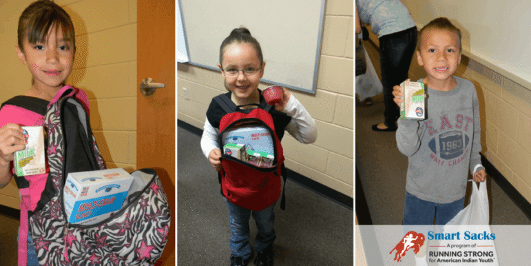 Native American children holding Smart Sacks food items provided to prevent hunger over the weekend