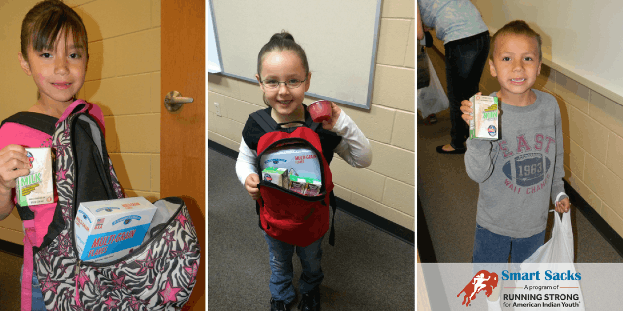 Native American children holding Smart Sacks food items provided to prevent hunger over the weekend