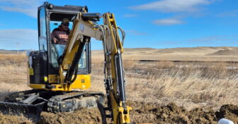 Excavator installing a water line to provide clean water for Native American families on Pine Ridge Reservation