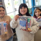 Native American children holding dental and hygiene kits provided by Running Strong for American Indian Youth program