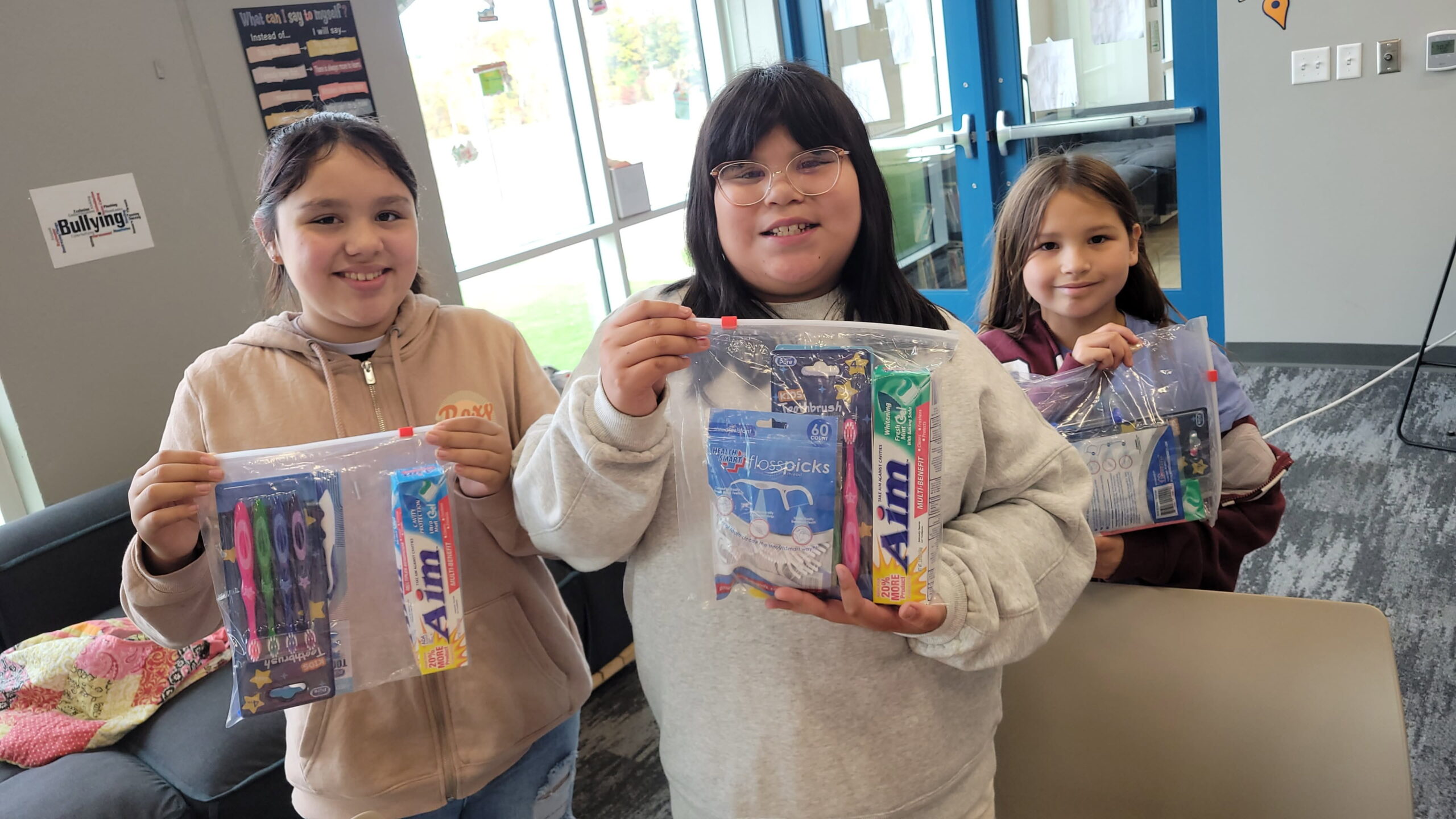 Native American children holding dental and hygiene kits provided by Running Strong for American Indian Youth program