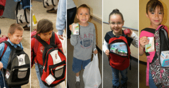 Five students holding backpacks and packaged food for Running Strong’s Smart Sacks weekend food program.