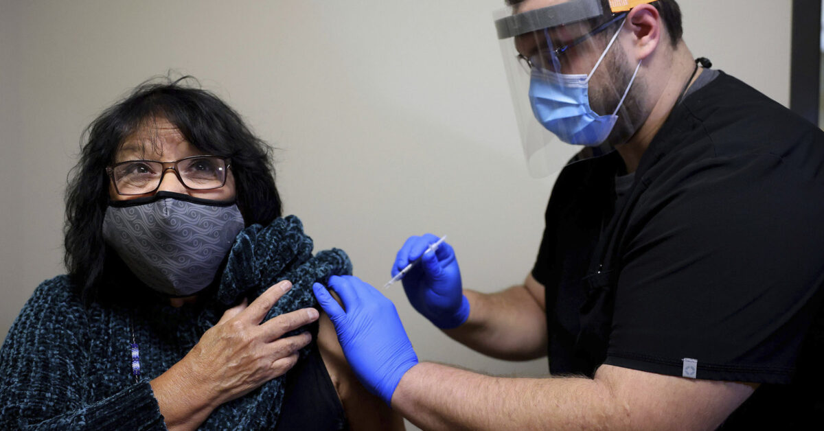 Meda Nix, a citizen of the Cherokee Nation and a Cherokee language speaker, receives a COVID-19 vaccine from Dr. Matthew Reece at the Cherokee Nation Outpatient Health Center Thursday, Dec. 17, 2020, in Tahlequah, Okla.(Mike Simons/Tulsa World via AP)