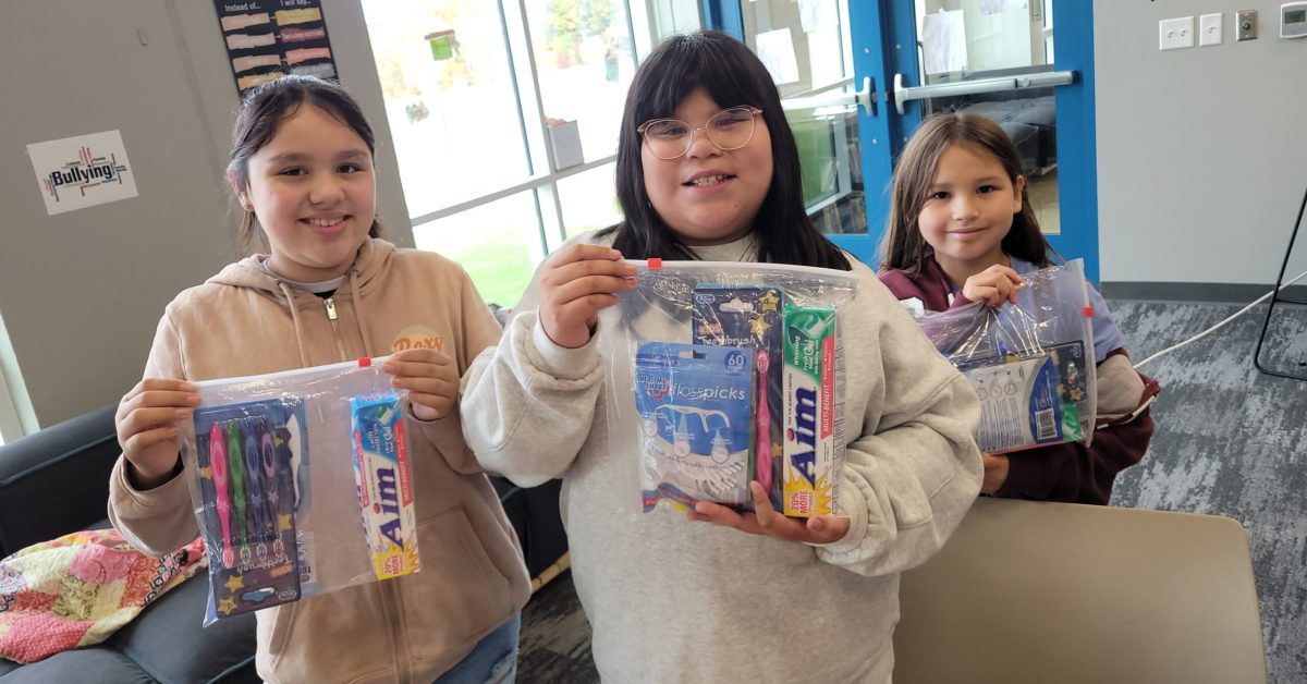 Native American children holding dental and hygiene kits provided by Running Strong for American Indian Youth program