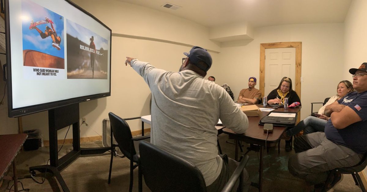 Presenter leading small group discussion with images on screen