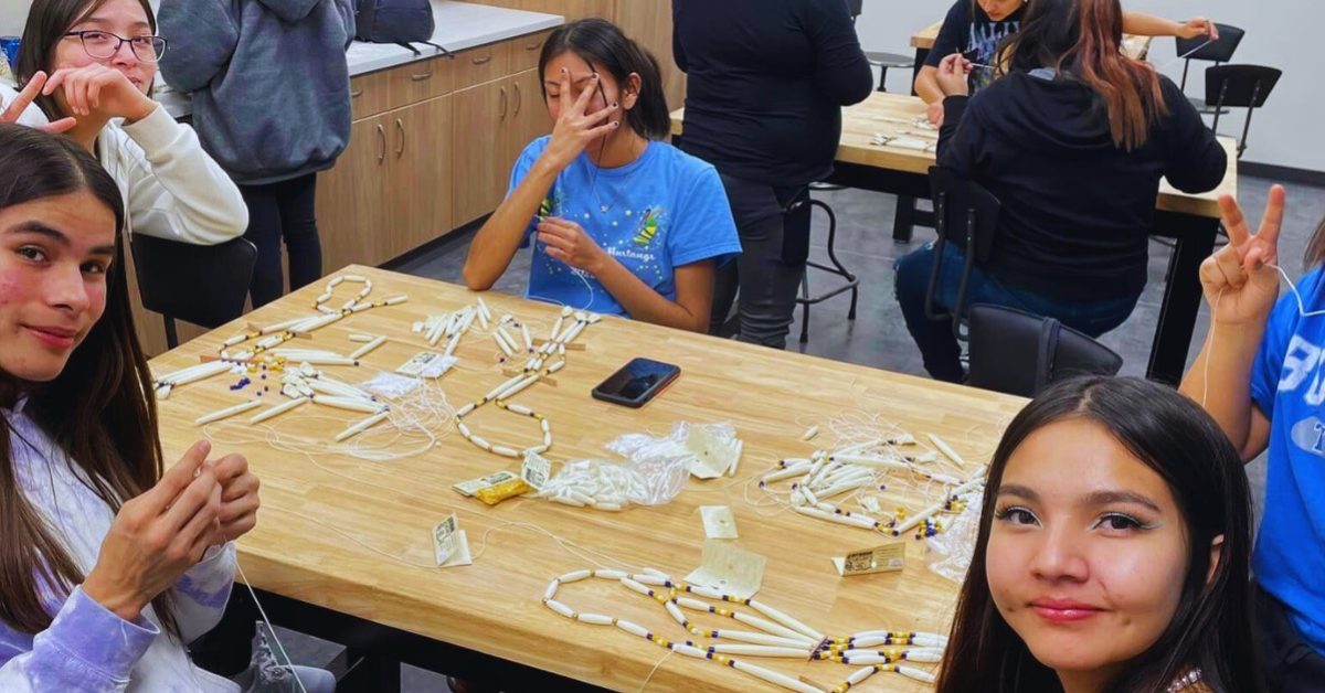 Lakota youth creating traditional breastplates during a cultural crafts class at Oyate Ta Kola Ku.
