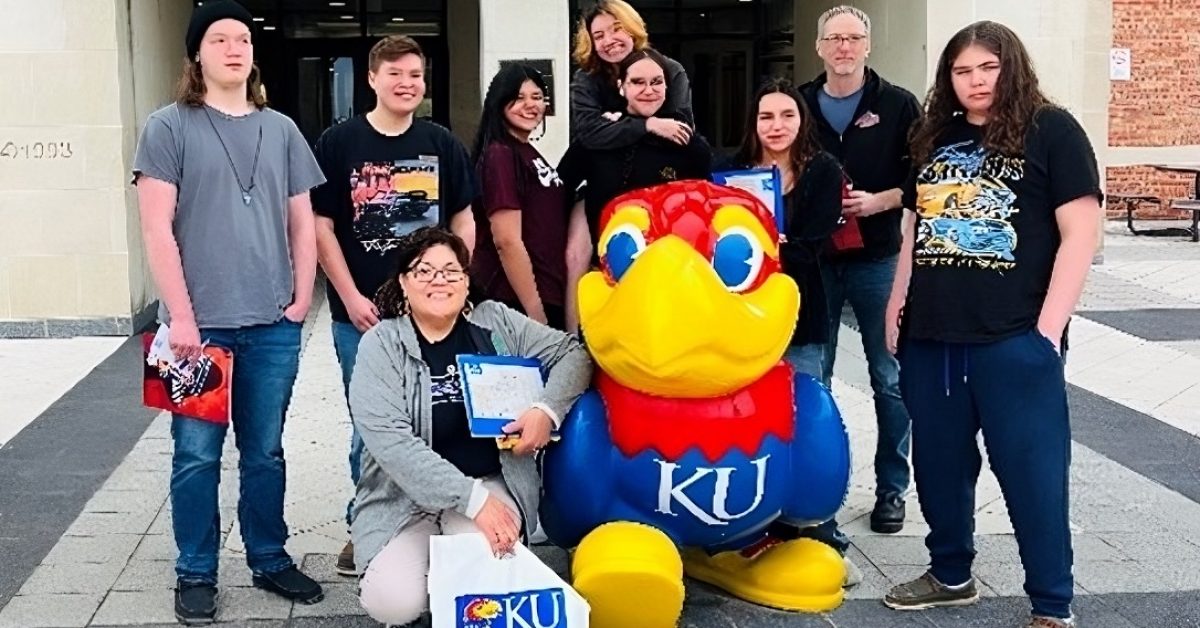 Group of students posing with KU mascot on campus tour