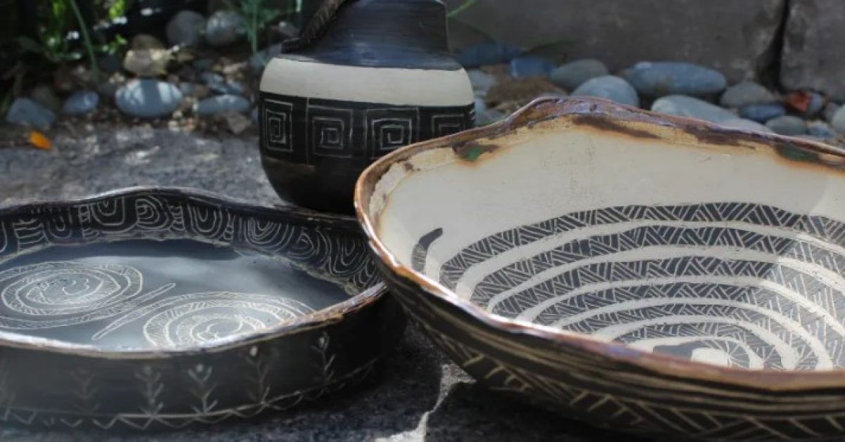 Handcrafted Native American pottery with traditional geometric designs displayed outdoors.