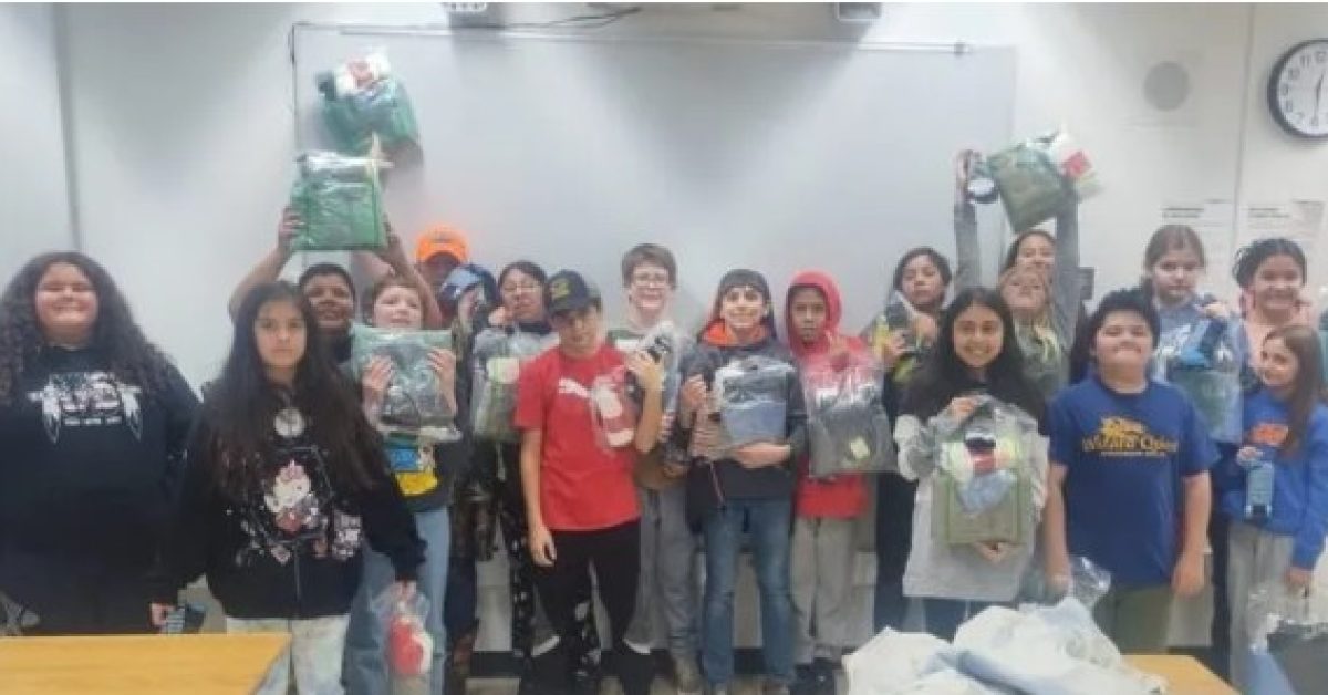 Native American students holding care packages in a classroom