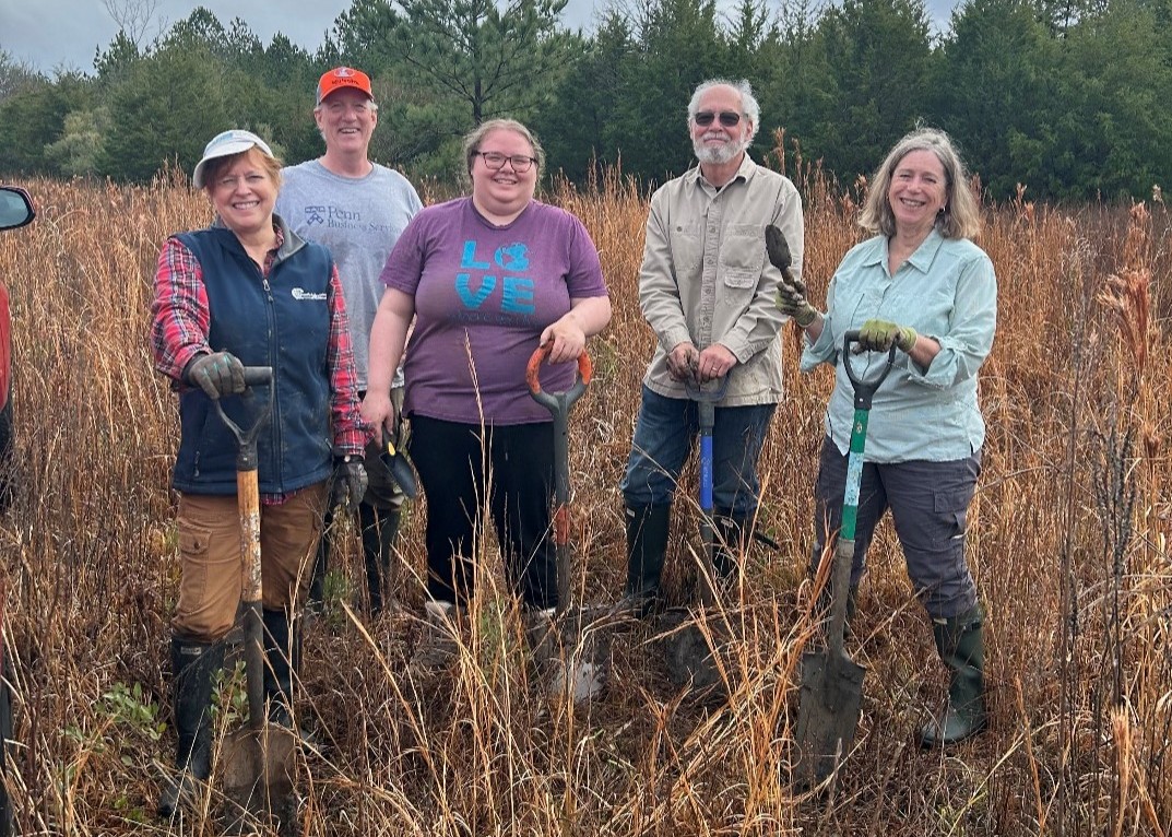 Adults with shovels work on restoring a field, an example of cultural-ecological stewardship in action.