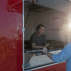 A Native entrepreneur serving a customer from his food truck, symbolizing community-driven business and economic sovereignty in Indian Country.