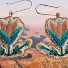 Two floral beaded earrings against a canyon backdrop