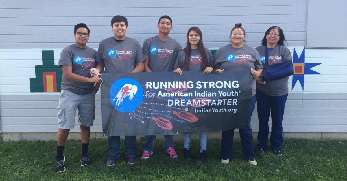 Dreamstarter youth leaders carrying the Running Strong banner