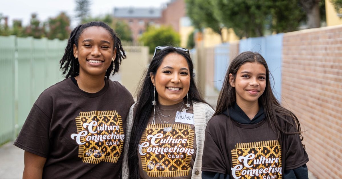 Nizhóní Begay standing with Native students during a college readiness and career exploration program