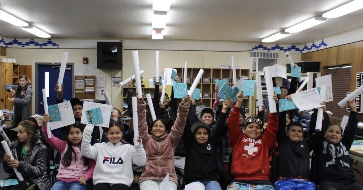 Students in a classroom holding Wailaki ABC books and rolled posters